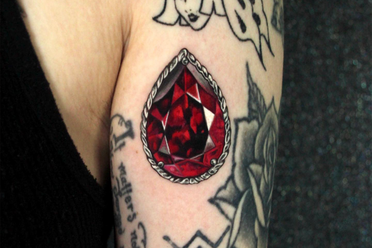 Realistic gem tattoo on the inner forearm