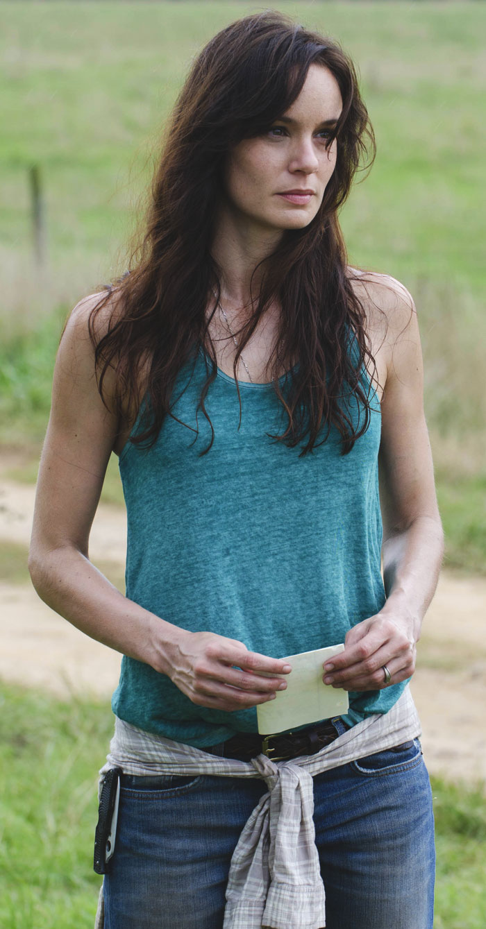 Lori Grimes looking into the distance with the paper in her hands
