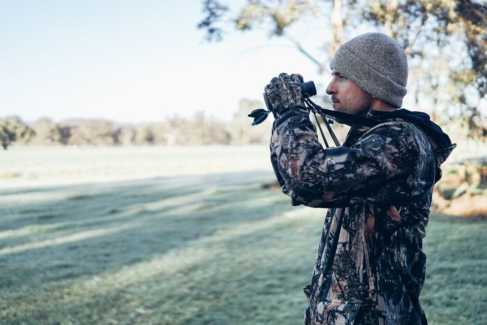 Man Looking Through Binoculars To See Into The Distance 