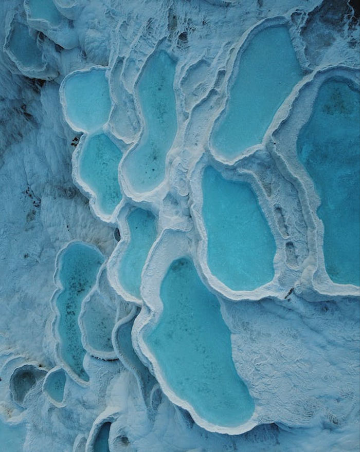 Multiple hot springs surrounded by snow 