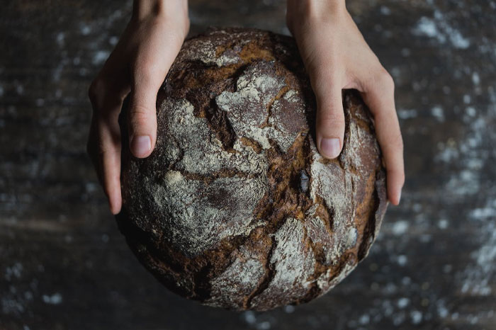 Person holding fresh loaf of bread 