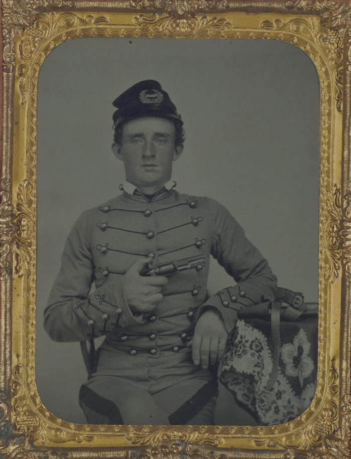 Black and white picture of George Armstrong Custer posing with gun