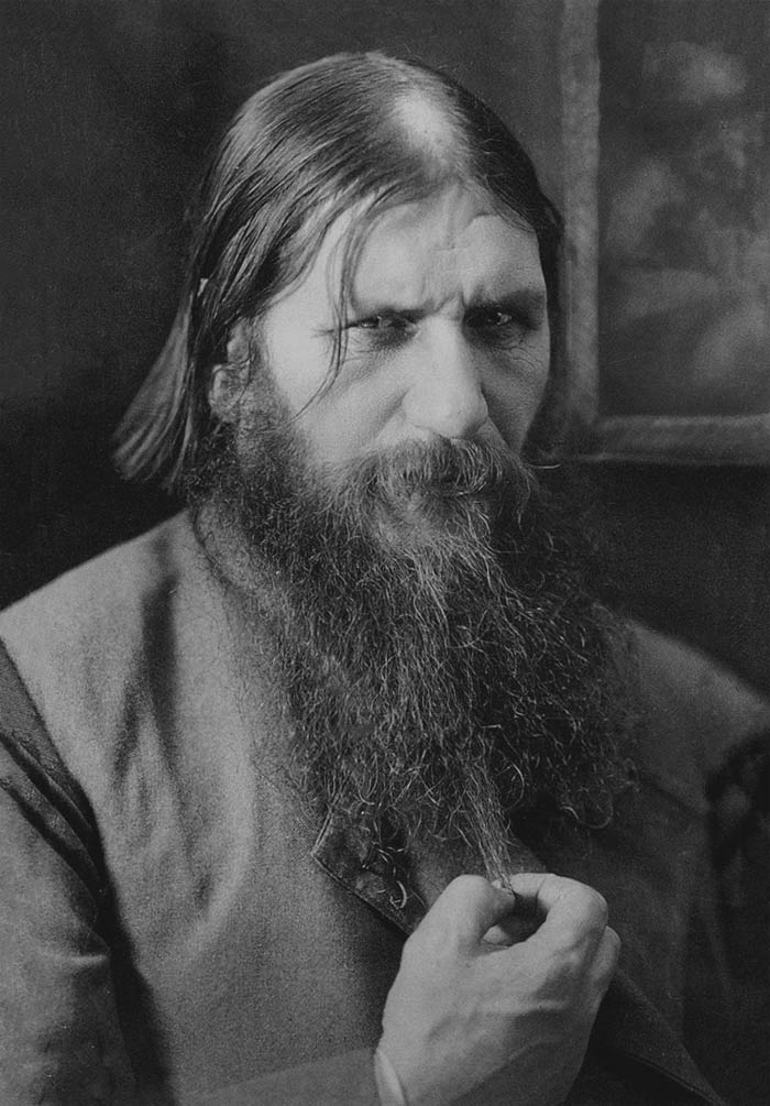 Black and white picture of Rasputin holding his beard