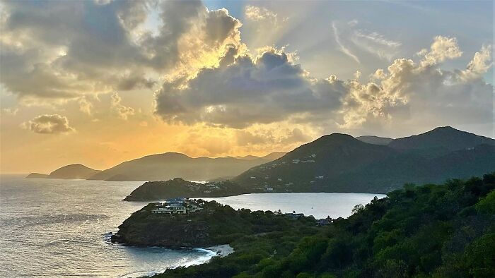 the sky during the sunset near the mountains with the sea