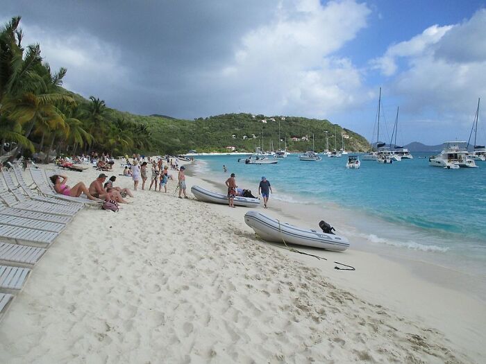 people on the beach with a lot of yachts nearby