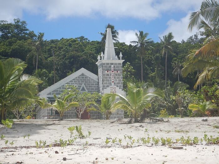 building with the cross near the palms in the earth