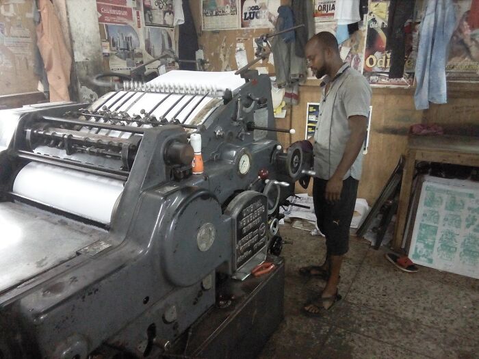 Man Operates A Massive Printing Press Machine 