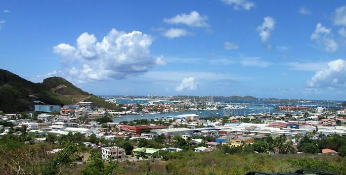 blue skies with white clouds under the city near the sea