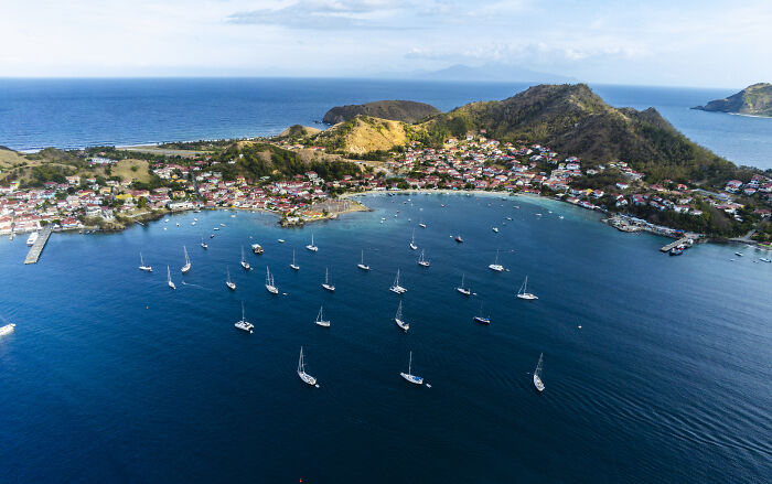 a lot of sailboat in the sea near the shores with buildings