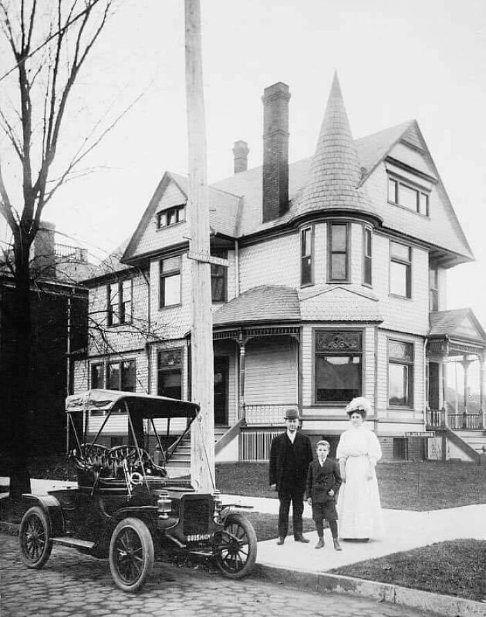 A Small Family In Front Of Their Home