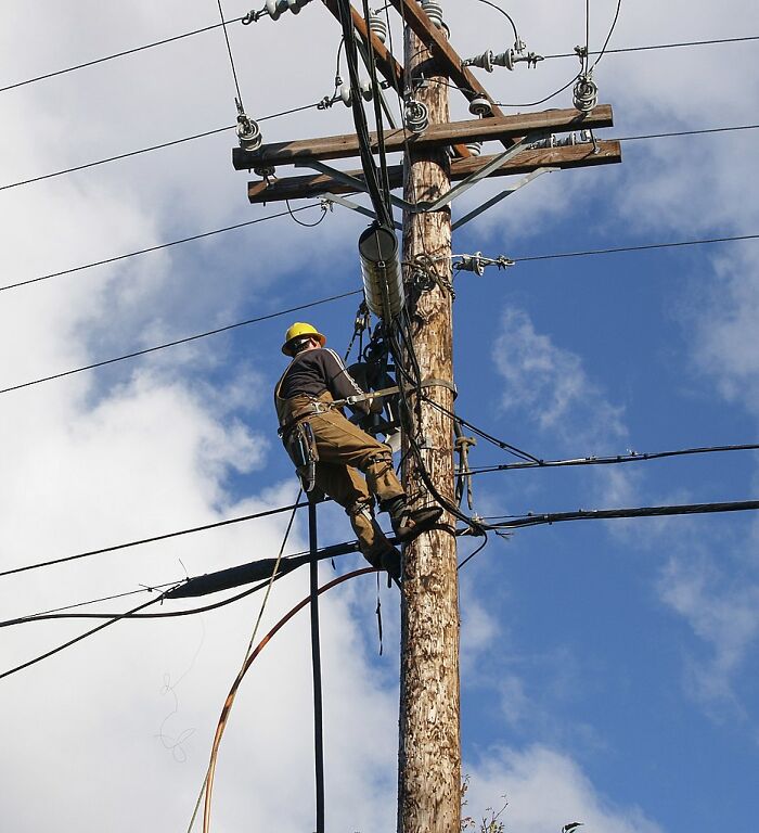 Lineman Working Up In Electric Tower 