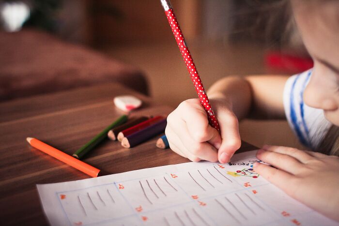 Girl Drawing On A Piece Of Paper 