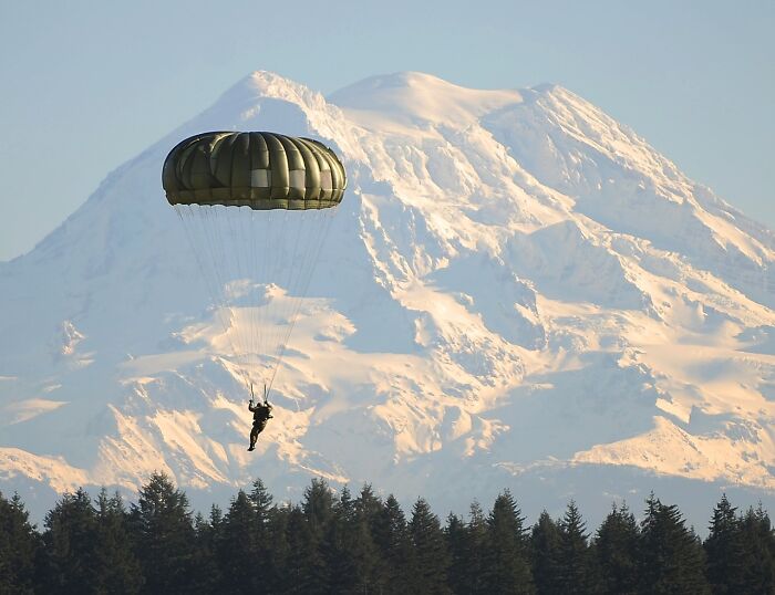 Man Landing With Parachute And Snowy Mountains In The Back 