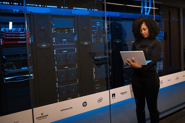 Woman Standing With A Laptop In The Server Room 