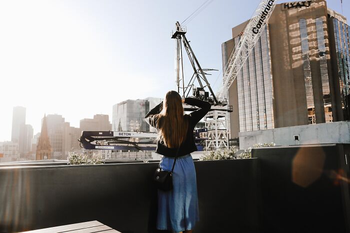 Woman Looking At The Roof Crane In The Back 