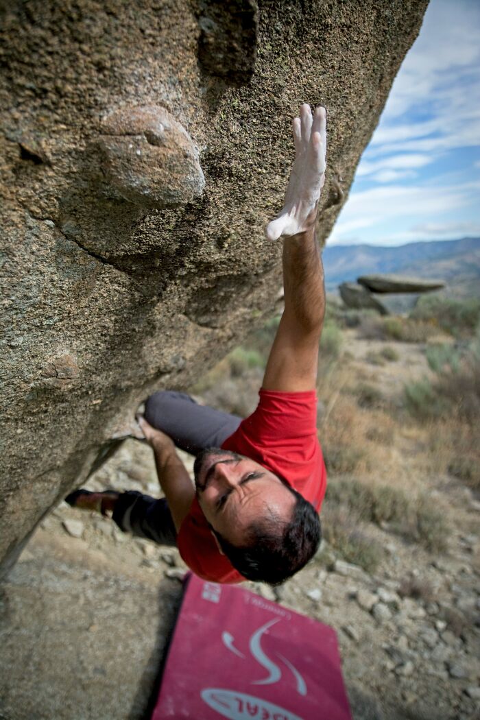 Man Rock Climbing On The Side Of A Mountain 