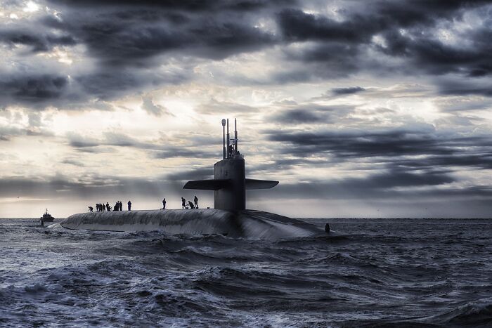 Half In Water Submarine With People Standing On Top Of It