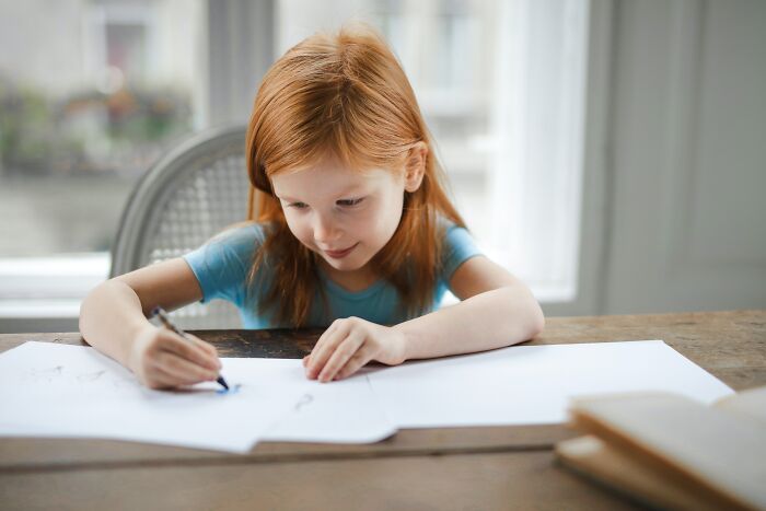 Girl Drawing On Piece Of Paper 