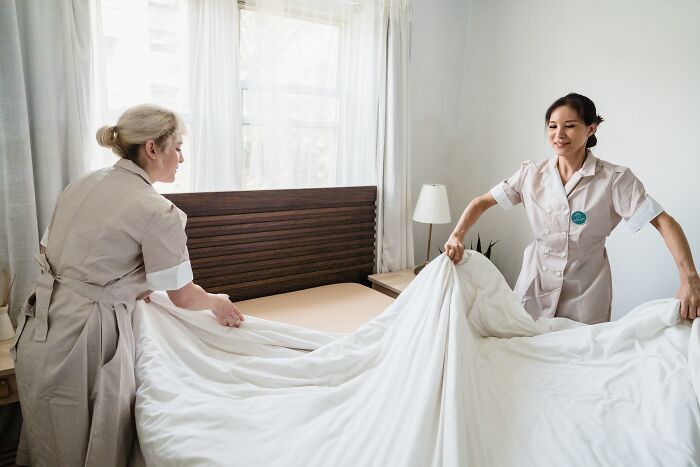 Maids Making Bed In A Room 