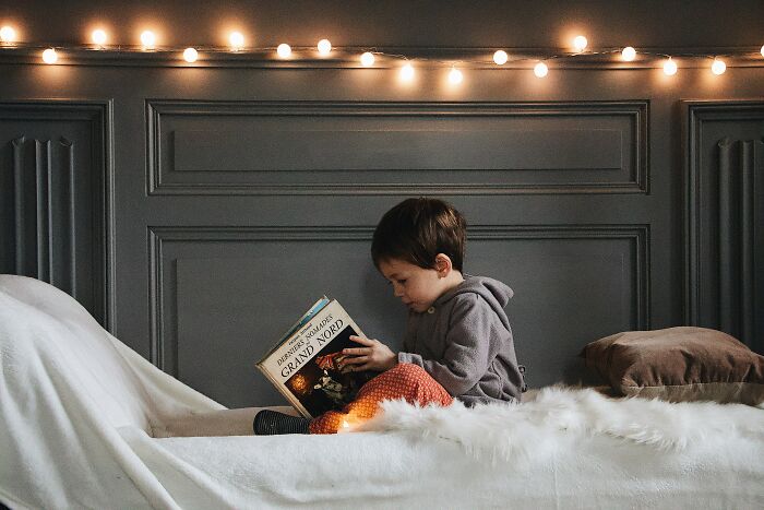 Kid In Bed Reading A Book