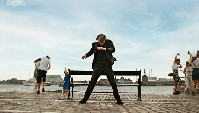 Martin from Another Round is dancing outside and a bench behind him