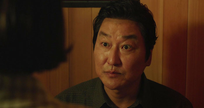 Kim Ki-Ttaek looking and talking from Parasite