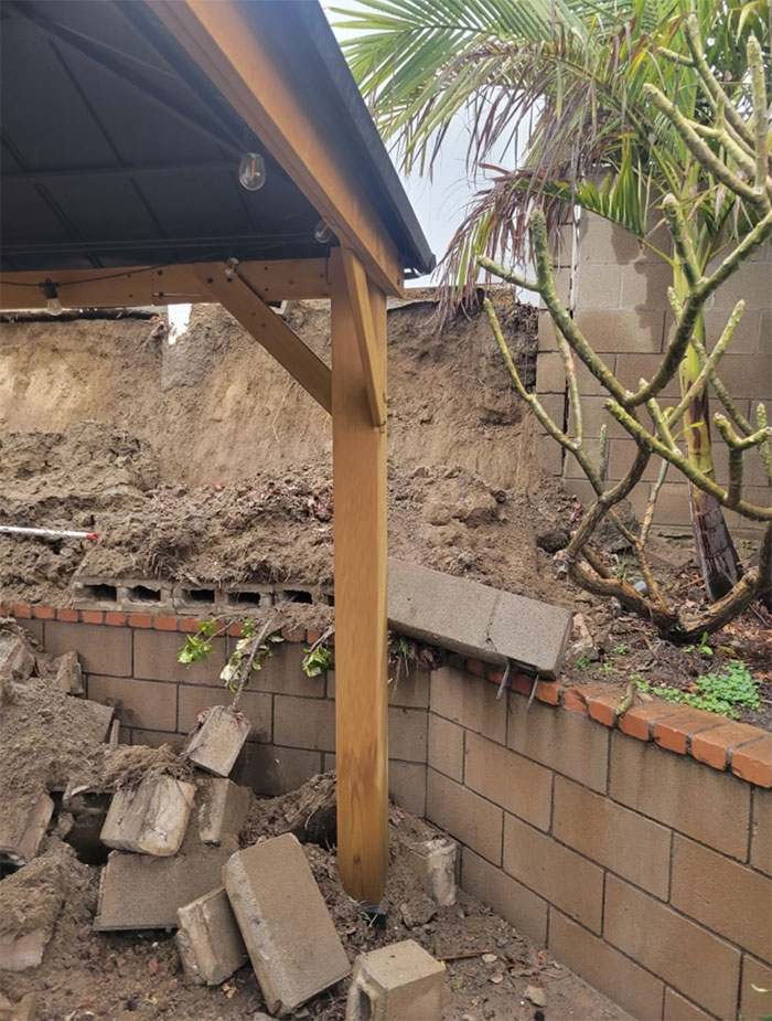 We Performed An Assessment Of A Failed Retaining Wall. You Can See Here That The Neighboring Home Sat Higher On The Hill. When Retaining Walls Are Built Without The Proper Drainage Solutions, It Can Cause Water To Accumulate Behind The Wall And, As The Pressure Increases, It Will Eventually Exceed The Strength Of The Wall, Causing It To Fail. This Is Called Hydrostatic Pressure