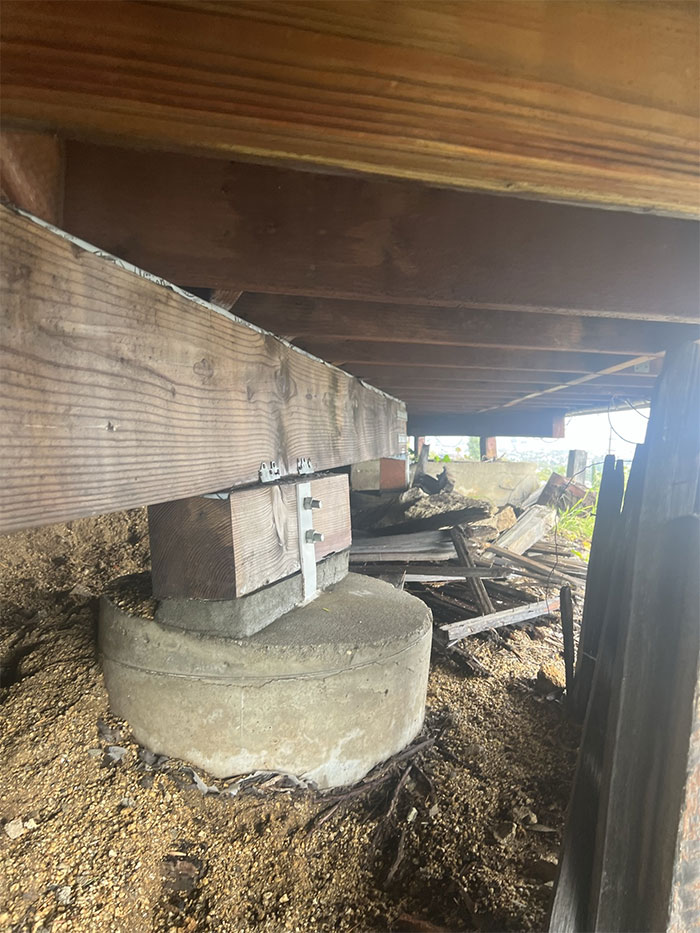 This Caisson And Grade Beam System Was Designed To Support A Deck. You Can See It Has Sunk Over Time. If You Take A Closer Look At The Connections, You Can See Newly Poured Concrete That Was Added As An Attempt To “Fix” The Issue. The Concrete Was Meant To Help Close The Gap And Provide The Support Needed To Keep The Deck Stabilized. While This May Seem Like A Quick Fix, It's Important To Note That A Sinking Caisson Can Indicate Serious Underlying Issues With The Soil Or Foundation Of The Structure