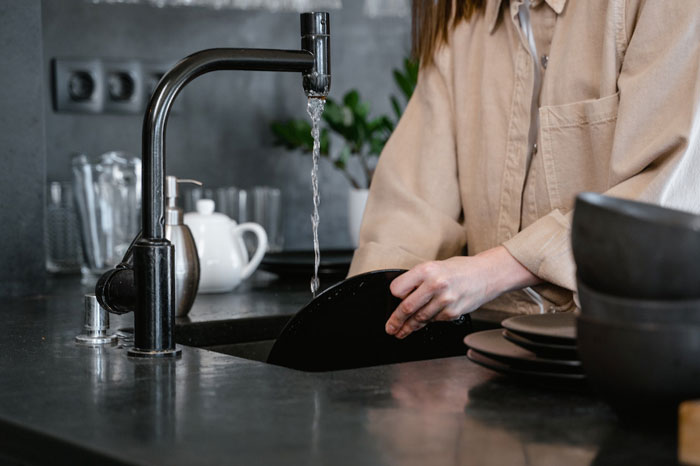 a woman washing a plate