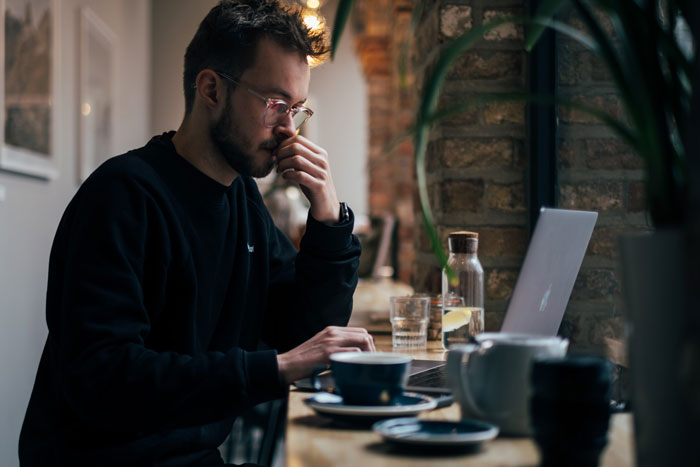 a man thinking and looking into the laptop