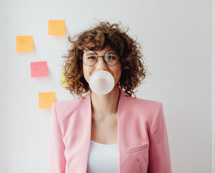 a woman in glasses with a bubble gum 