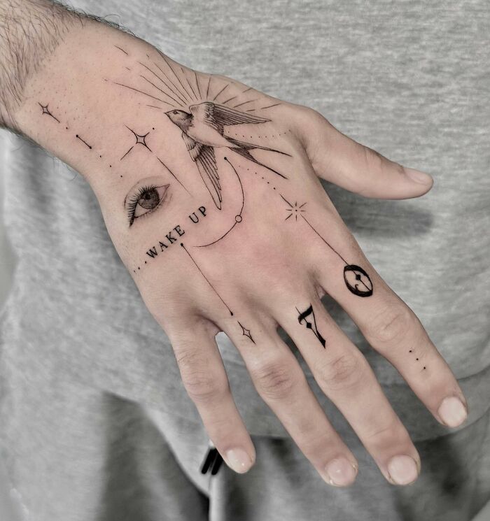 Black tattoo composition on hand with swallow, eyes, and lettering