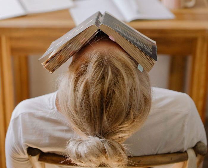 a person sitting on the chair with a book on the face