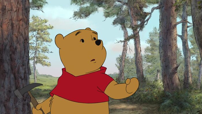 Winnie The Pooh holding a pickaxe in his hand