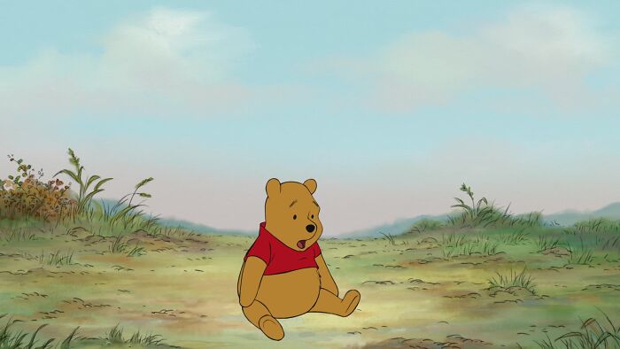 Winnie the Pooh sitting in the fields