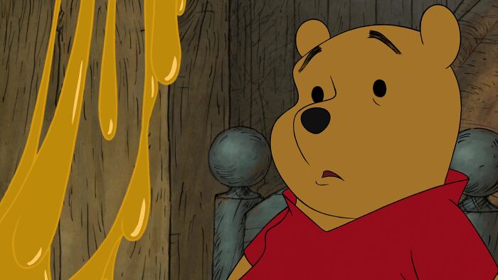 Winnie the Pooh looking at the pot of honey