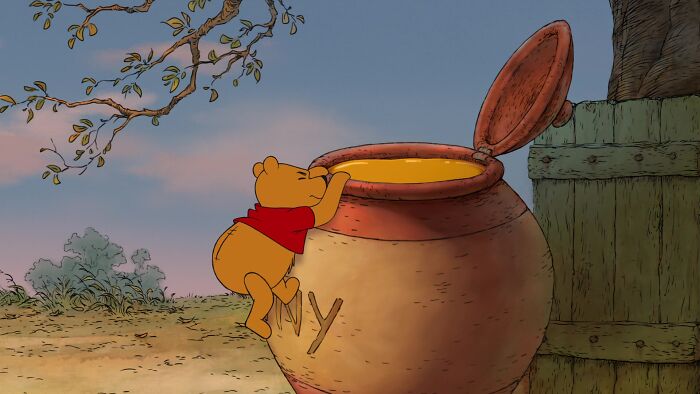 Winnie the Pooh trying to reach honey from the honey pot