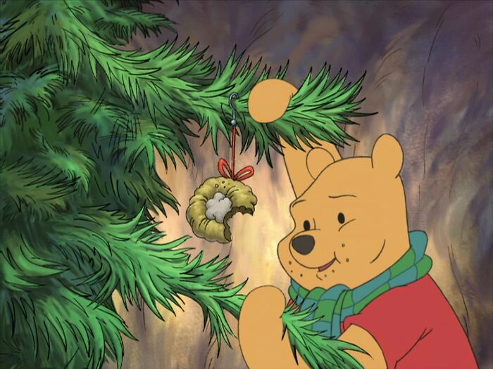 Winnie the Pooh enjoying Christmas time near Christmas tree