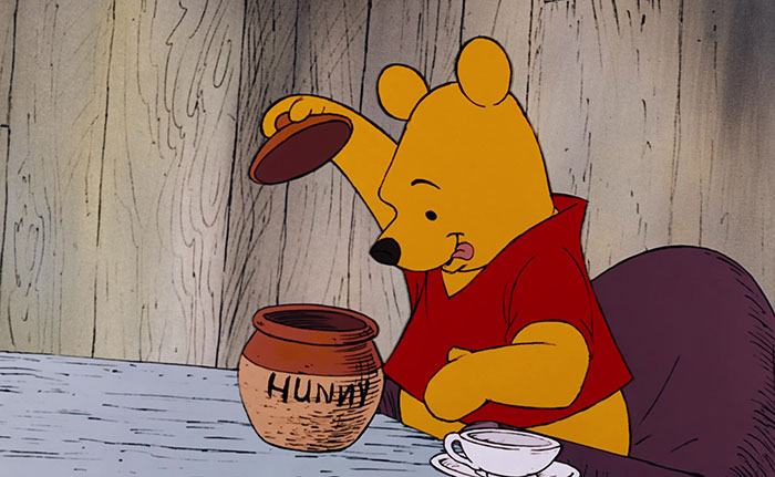 Winnie the Pooh preparing to eat honey