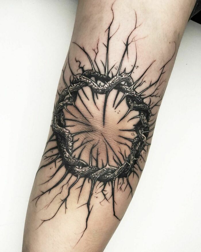 woven thorny branches around an elbow tattoo