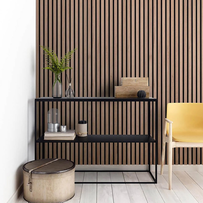 Vertical brown wood wall in a room with black low shelf and yellow chair