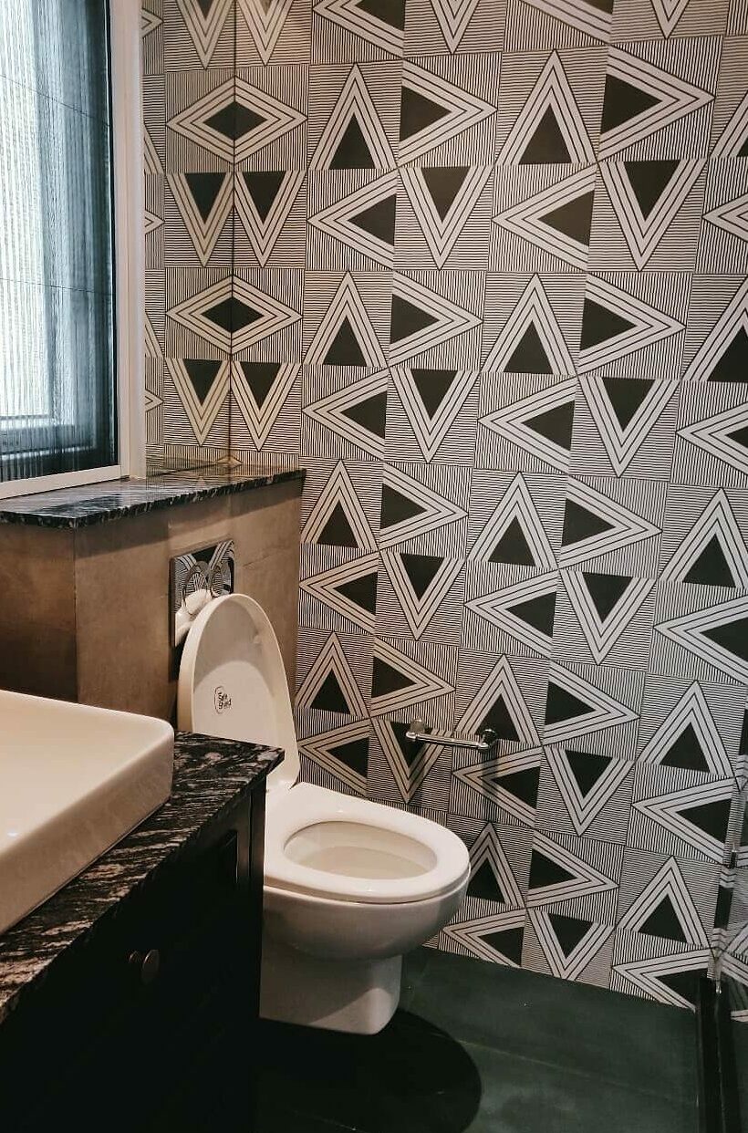 Bathroom with black geometric wallpaper toilet and sink