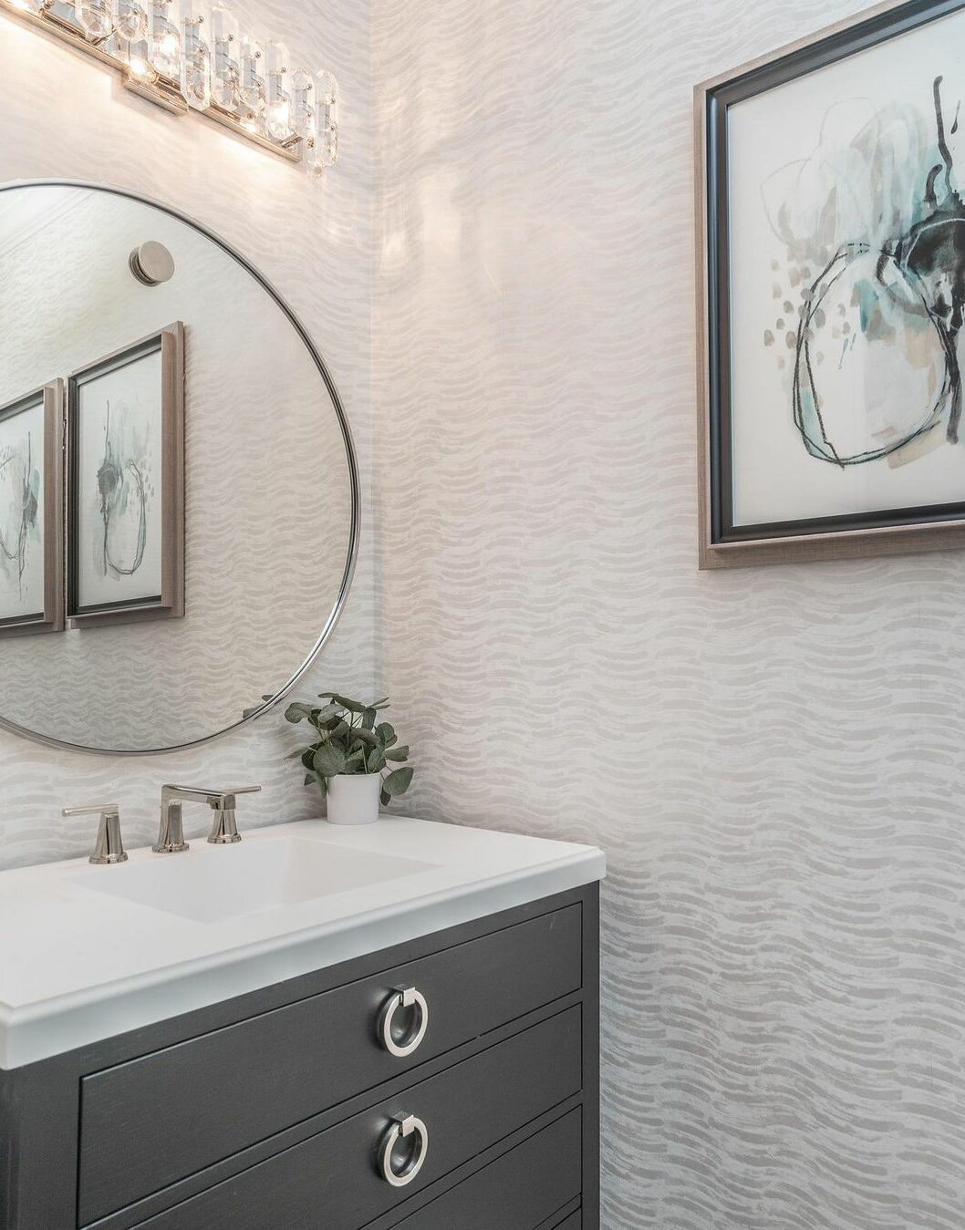 Bathroom with gray wavy wallpaper and black cupboard with sink