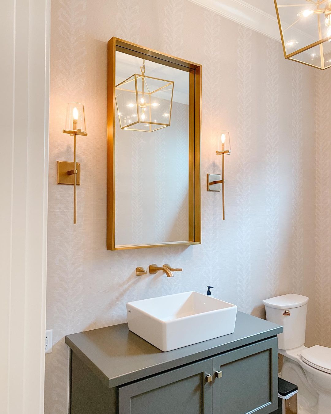 Bathroom with neutral pink wallpaper and cupboard with sink