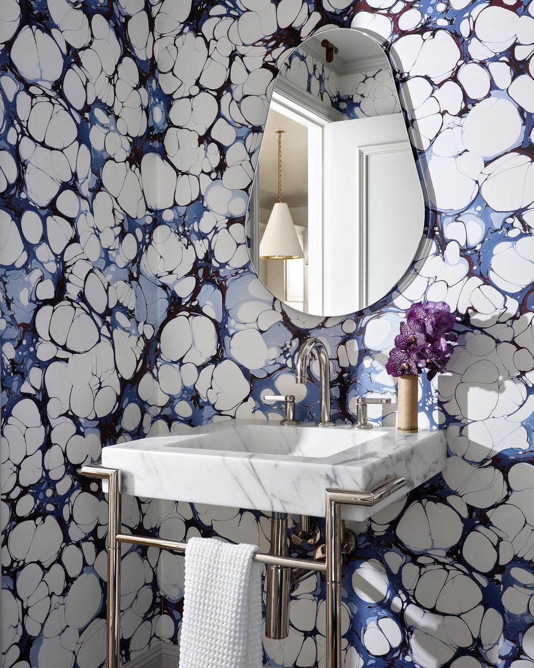 Bathroom with blue cloud wallpaper with marble sink