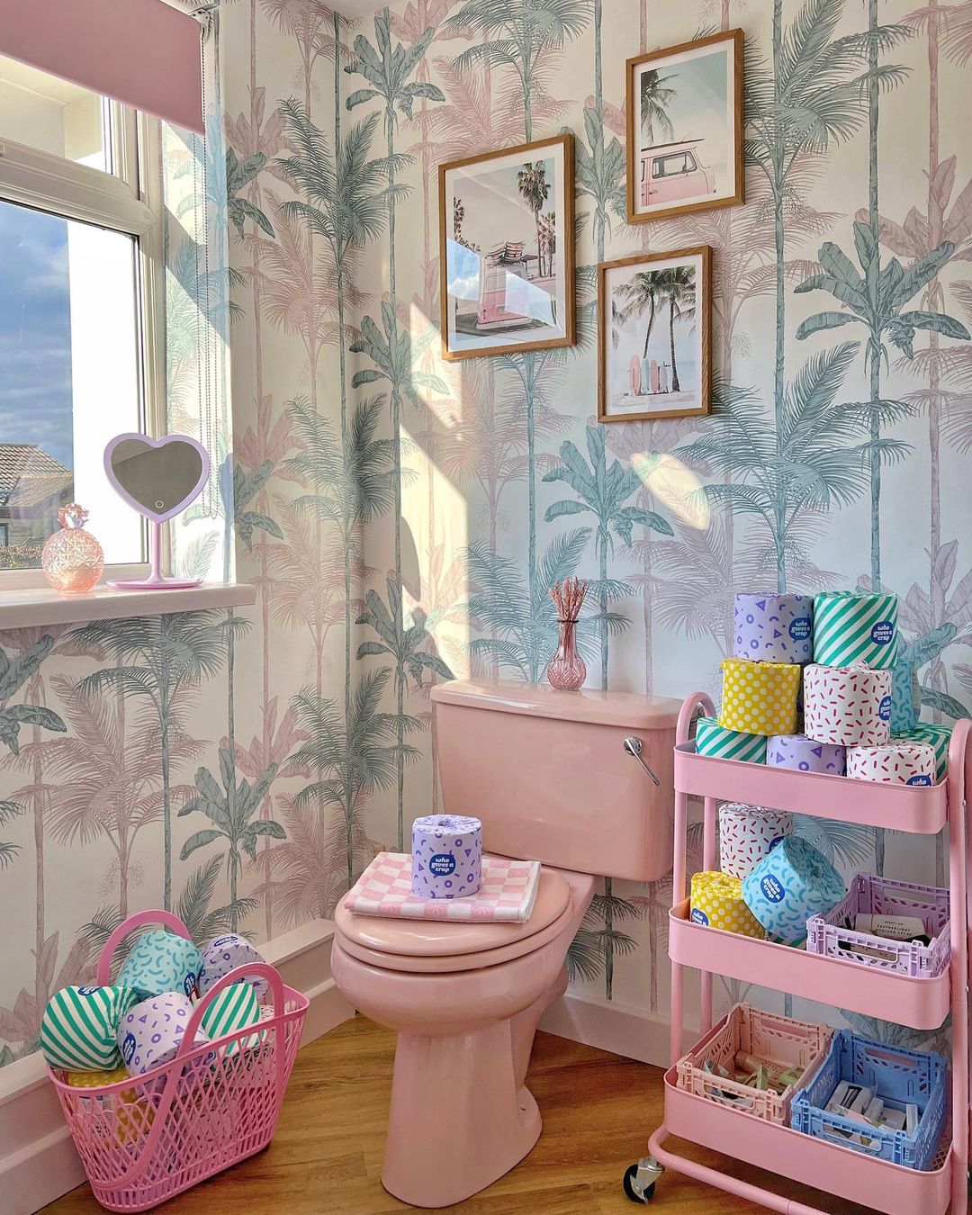 Bathroom with pastel tropical wallpaper and pink toilet