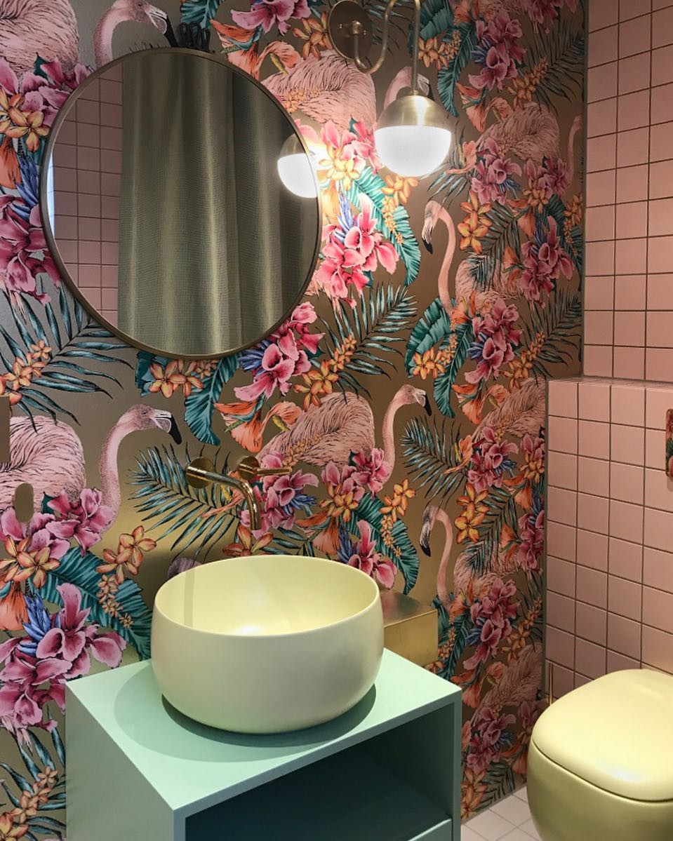 Bathroom with bright flower and flamingo wallpaper and sink