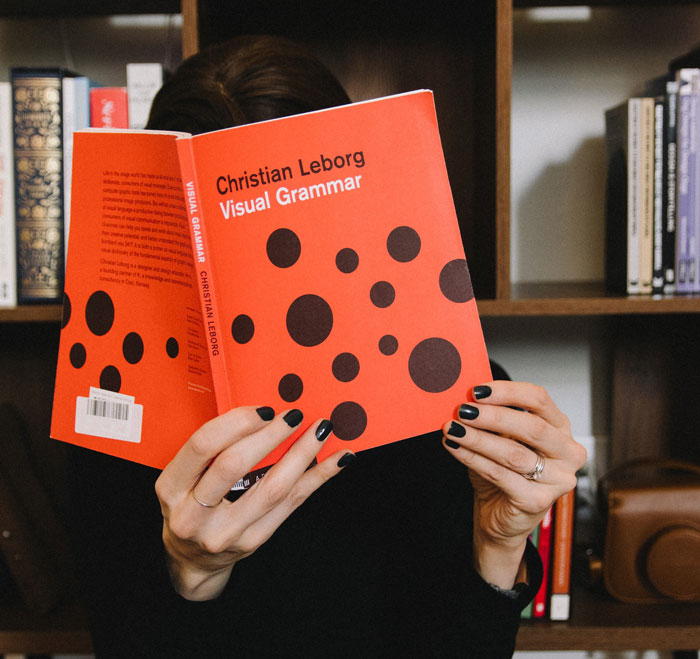 a person holding orange and white polka dot paper