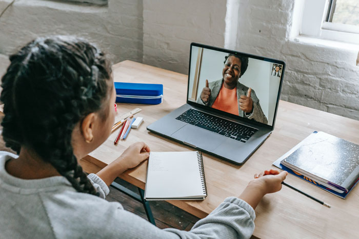 a girl speaking with her teacher online