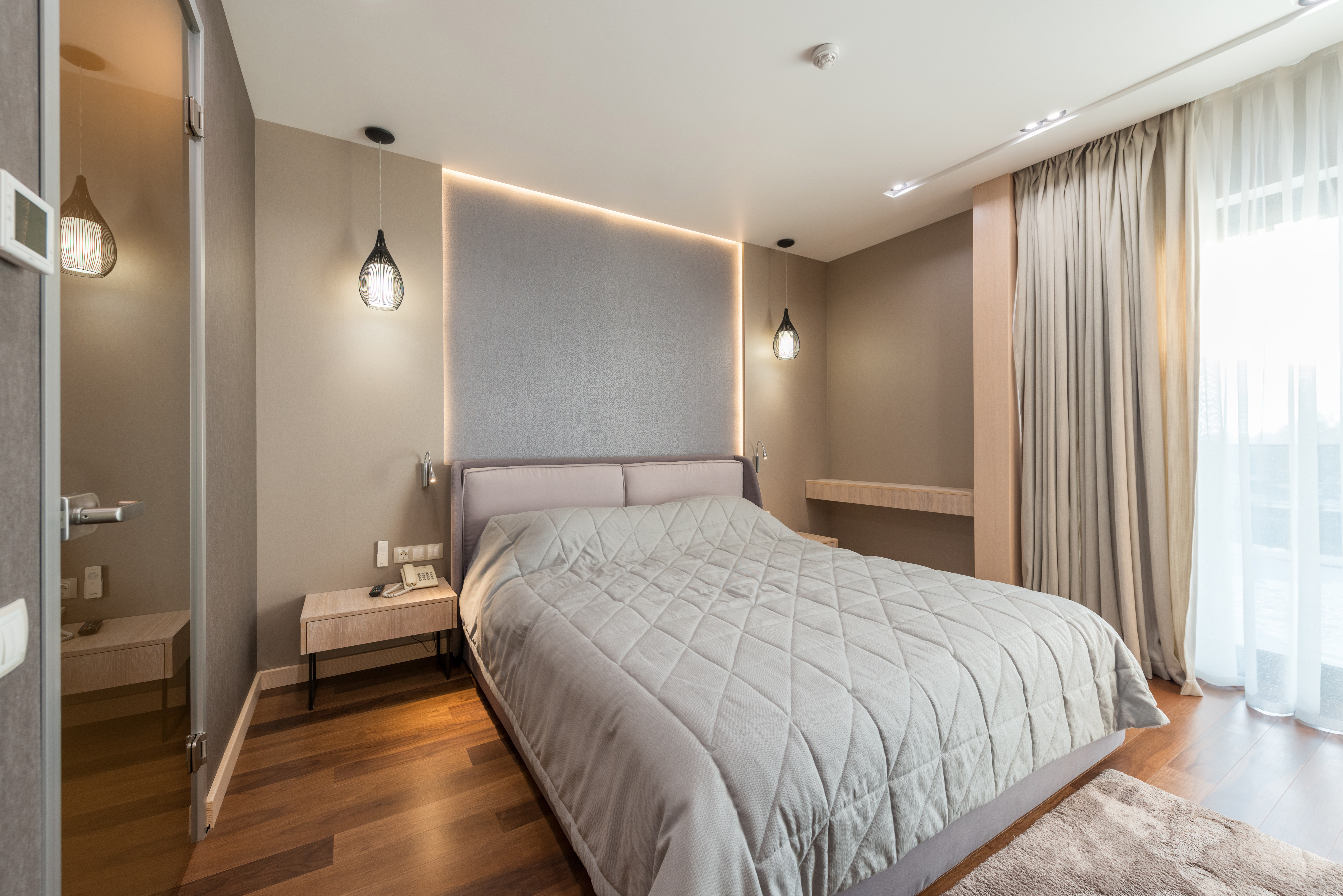 bedroom interior with parquet floor and comfy bed 